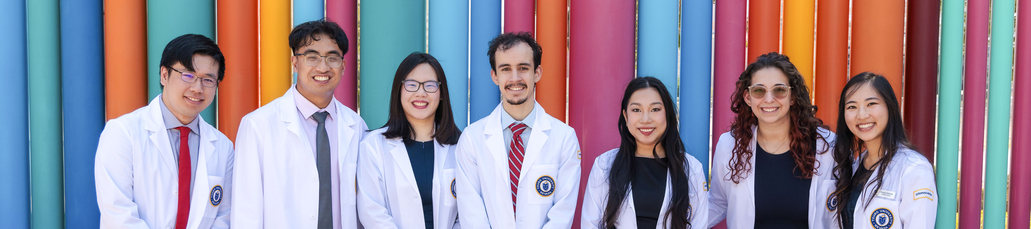 Osteopathic Medicine students wearing their white coats pose for a group photo at the ceremony.