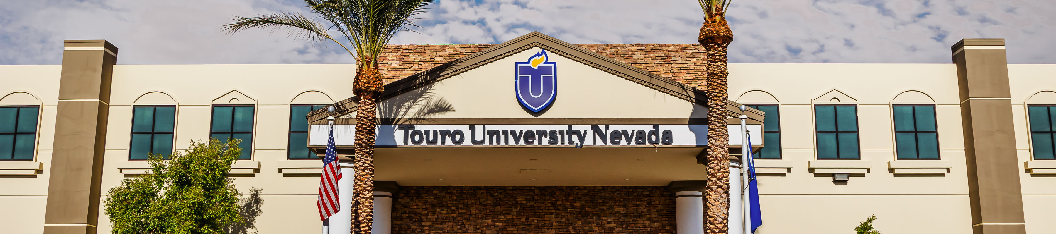 Exterior view of the front entrance of Touro University Nevada building, featuring the university logo