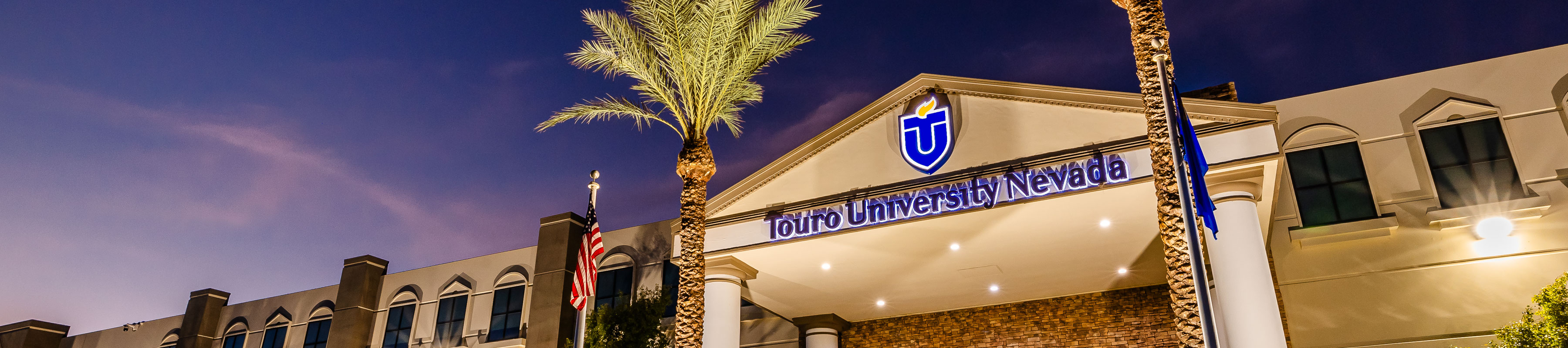 Exterior view of the front entrance of Touro University Nevada building, featuring the university logo