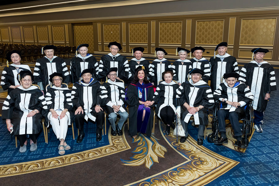 holocaust survivors wearing caps and gown at commencement