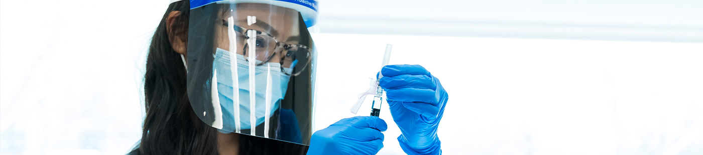 student in protective gear preparing a flu shot