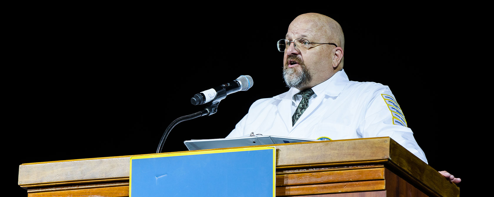 Dr. Andrew Priest speaks at the podium during a Touro Nevada white coat ceremony