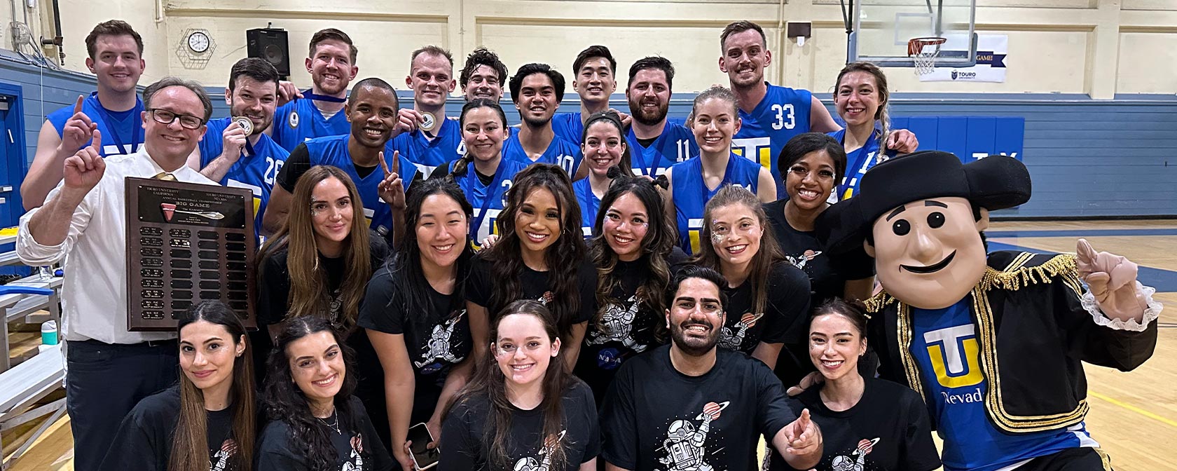 The 2023 Big Game participants join the Touro Nevada mascot on the court after the game for a group photo.