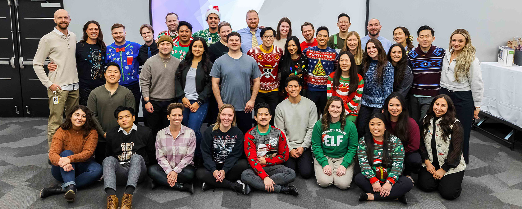Physical Therapy students gather for a photo in their holiday sweaters during the DPT holiday celebration.