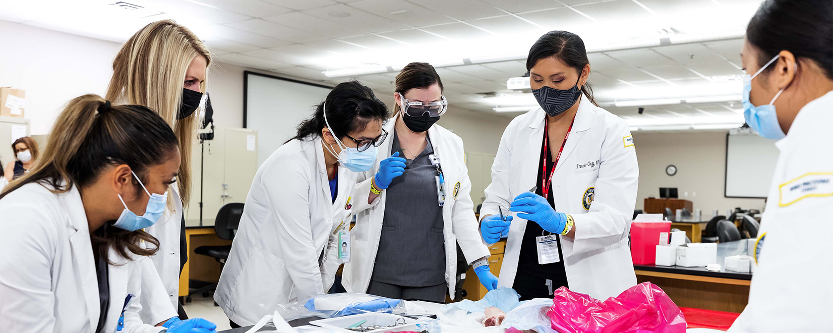 Touro School of Nursing students practice suturing in a classroom.