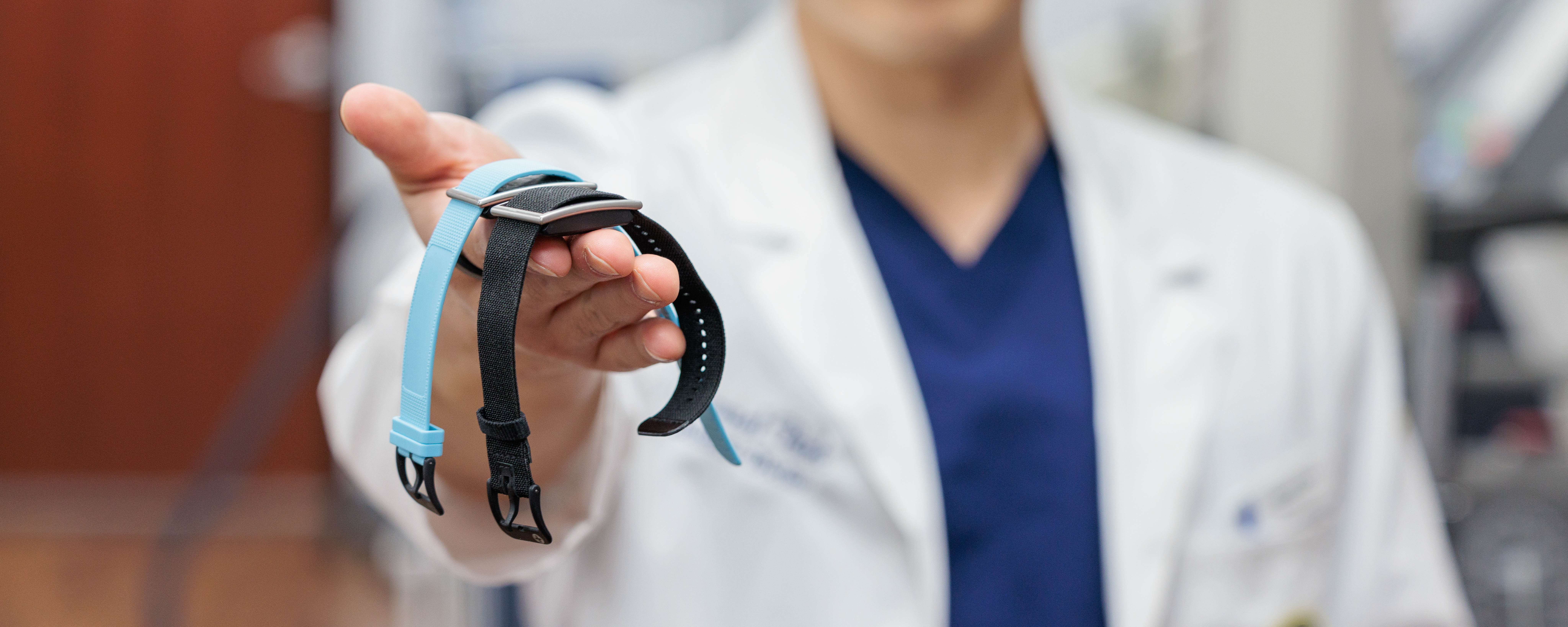 College of Osteopathic Medicine student, Samuel Park, holds two waterproof smart wrist devices that will gather participant data for the research project.