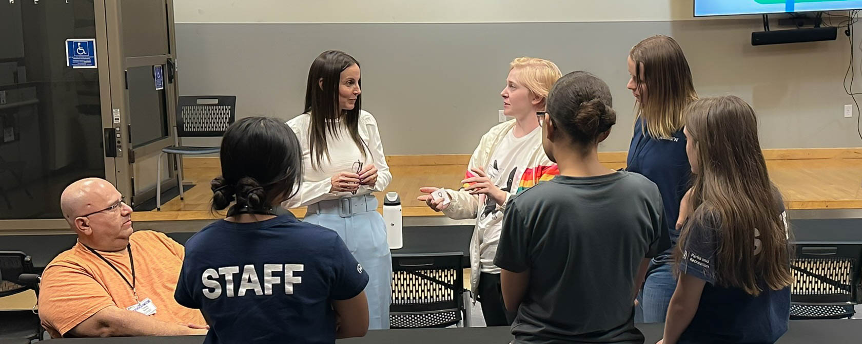 Board Certified Behavioral Analyst, Jennifer McConnell, talks with a group of Henderson after-school program faculty during the training session.