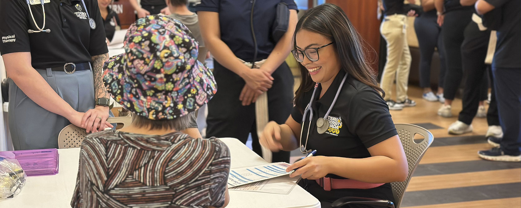 A physical therapy student speaks with a patient during a fall prevention clinic for seniors.