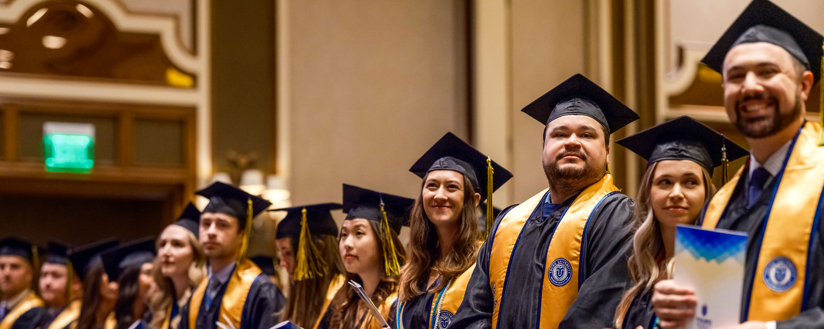 Graduating students in their caps and gowns, stand together during the commencement ceremony.