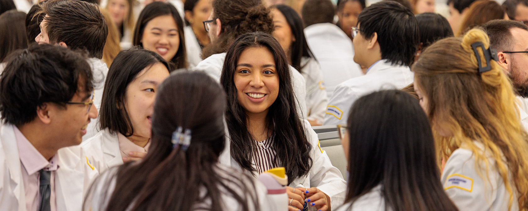 Students from both colleges work in groups to discuss the diverse medical and healthcare practices represented at the event.