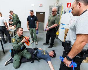 LVMPD officers gather to practice applying a tourniquet during a live training demonstration